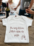 Witte babyromper met tekst Nu nog klein later aan de wijn en tekeningen van flesje en wijnglas
